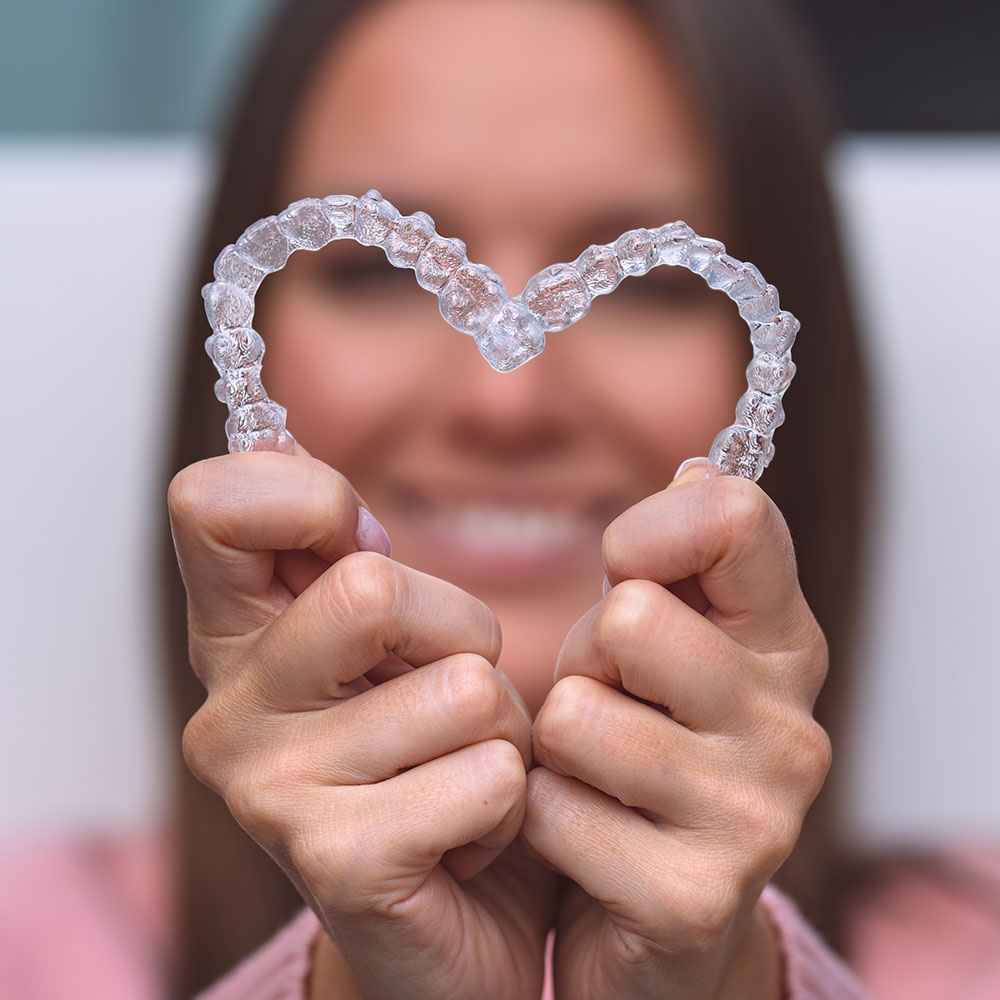 A person is holding up a small, clear plastic tray with a single toothbrush-shaped object inside it.