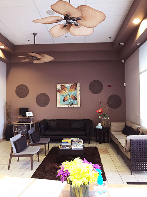 An interior room with a ceiling fan, brown walls, and a modern decor style.