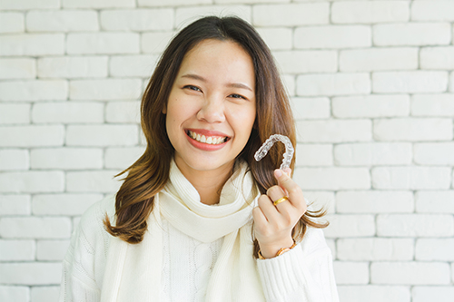 A woman holding a toothbrush in front of her face.